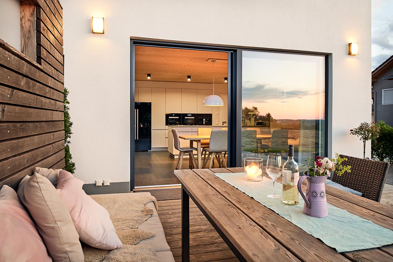 Massivholzhaus Terrasse mit Blick in die Küche